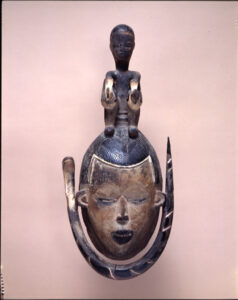 Female Mask Surmounted by a Seated Figure