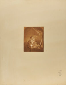 Une femme travaillant a la lueur d’une chandelle