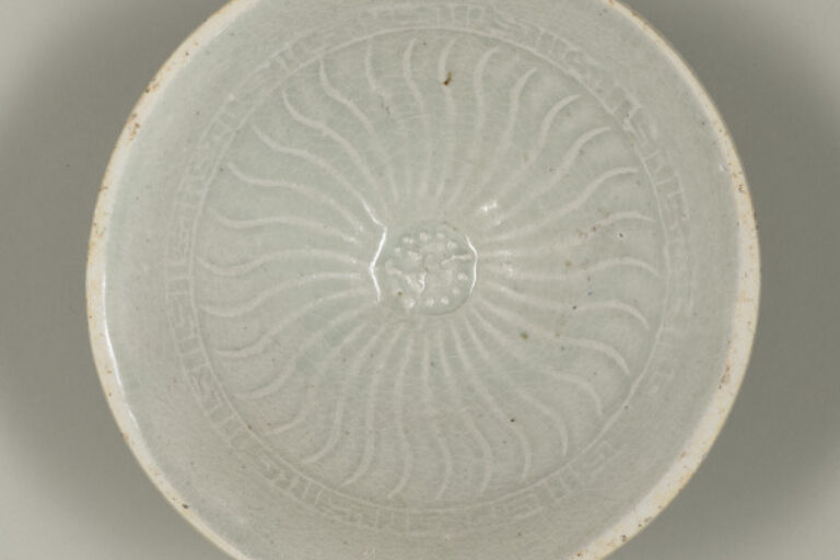 Bowl with Molded Flower at Center and Wavy Lines on Inside