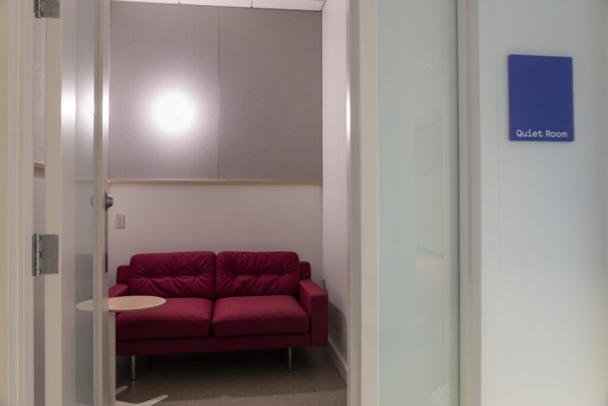 The Quiet Room featuring a red couch in a small room.