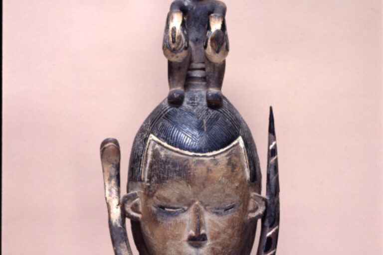 Female Mask Surmounted by a Seated Figure