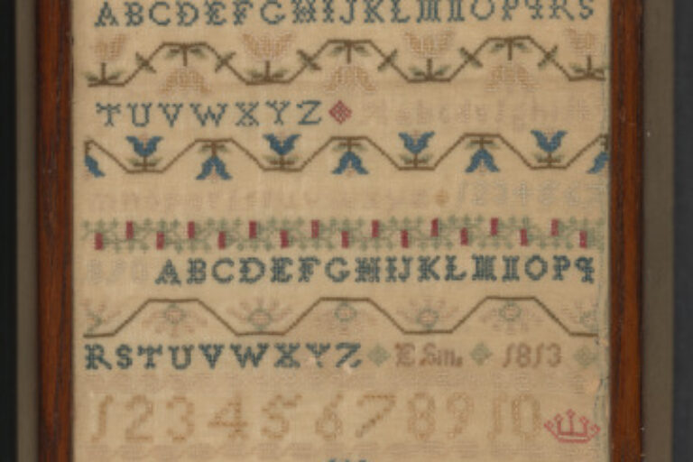 Band sampler with alphabets, floral baskets, etc.